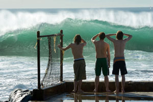 three youths watching surf